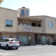 Two-story beige commercial plaza with parked cars