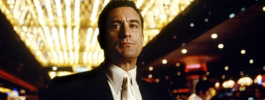 Man in suit under casino marquee lights