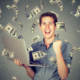 Man celebrating with laptop as money rains
