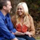 Smiling couple sitting outdoors holding hands