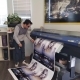 Person checking large-format poster printer output