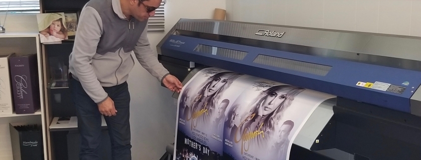 Person checking large-format poster printer output