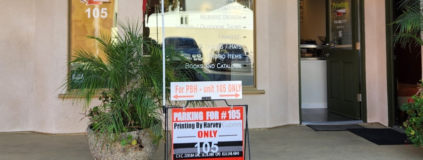 Print shop storefront with reserved parking sign