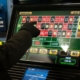 Gloved hand selecting bet on electronic roulette screen
