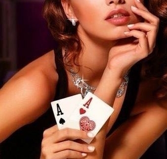 Glamorous woman holding poker aces with chips