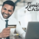Smiling man holding credit card at laptop
