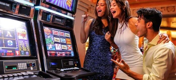 Three friends cheering at casino slot machines