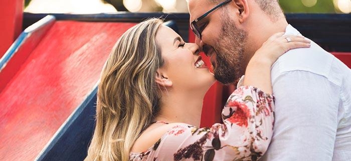 Smiling couple embracing by colorful playground slide