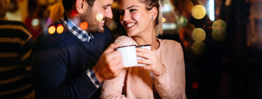 Smiling couple sharing coffee at cozy cafe
