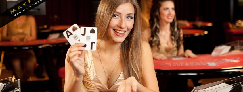 Smiling casino dealer showing blackjack hand