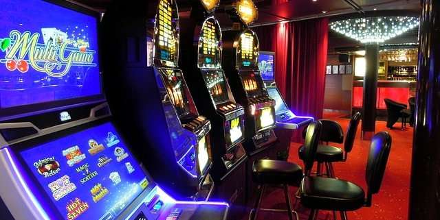 Row of illuminated casino slot machines and stools