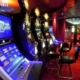 Row of illuminated casino slot machines and stools