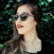 Woman wearing sunglasses against leafy background