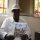 Man wearing hat reading brochure indoors