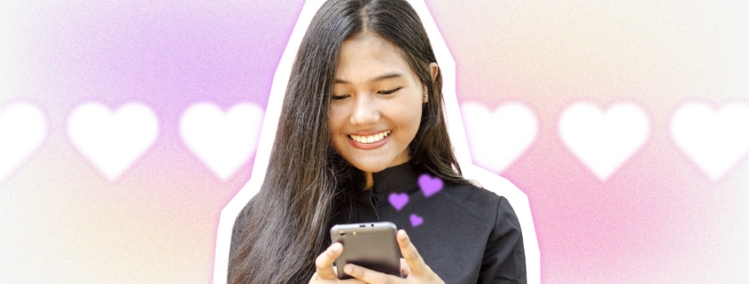 Smiling woman using smartphone with floating hearts