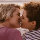 Couple kissing on a sandy beach at sunset