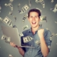Happy man with laptop amid flying cash