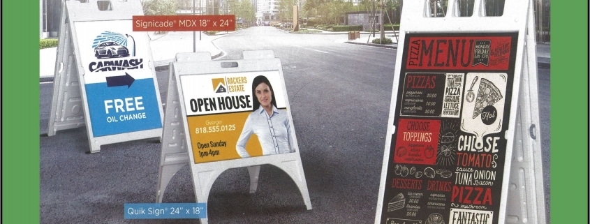 Three A-frame sidewalk advertising signs